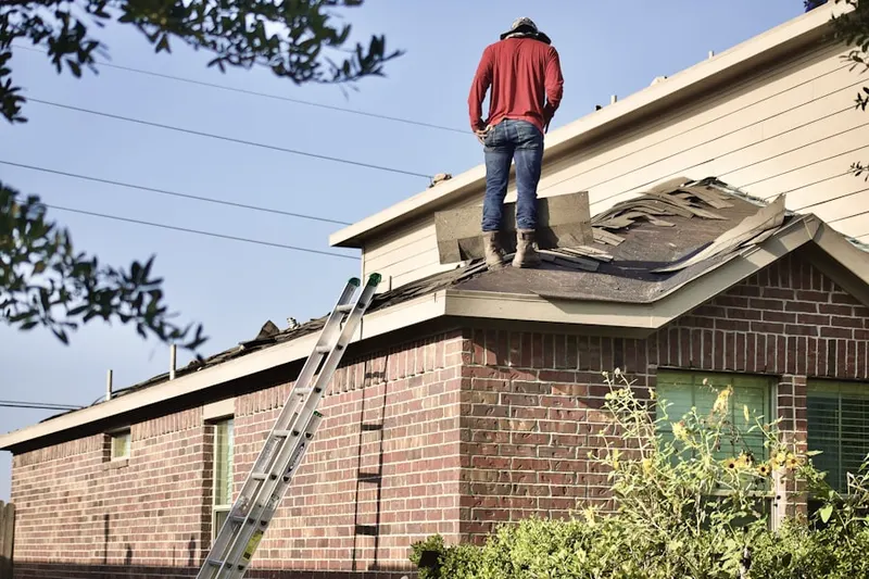 Professional roofer working on a residential roof in Acres Home